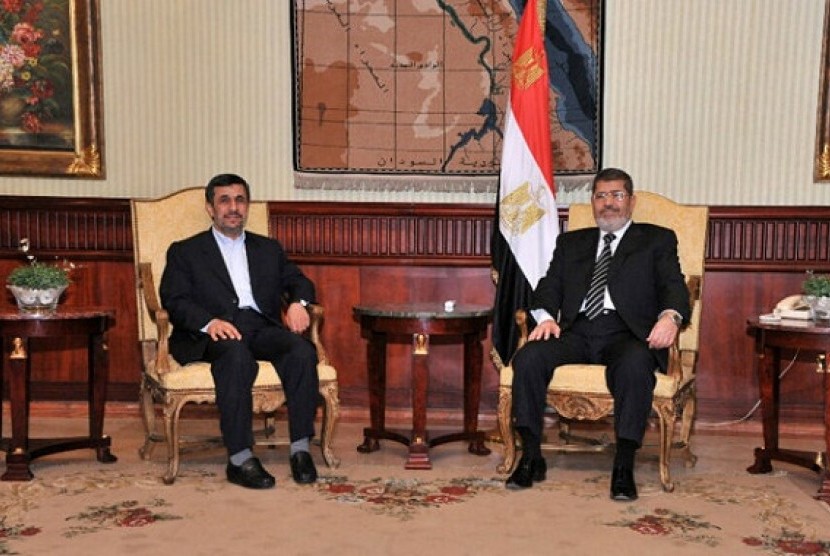 Iran's President Mahmoud Ahmadinejad (left) and Egyptian President Mohammed Mursi pose for photographers in Cairo, Egypt, Tuesday.