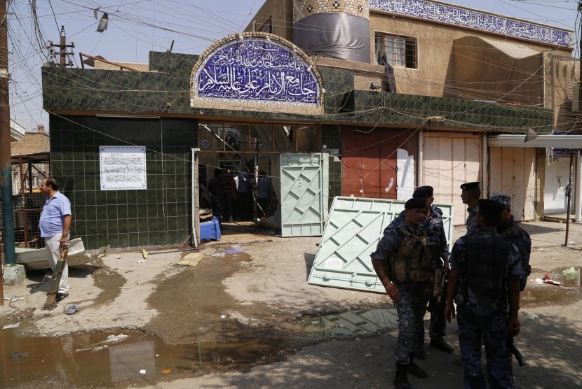 Iraqi security forces stand guard outside a Shi'ite mosque after a suicide bomb attack in the New Baghdad district, eastern Baghdad, August 25, 2014. A suicide bomb attack in a Shi'ite mosque in Baghdad on Monday killed at least nine people and wounded 21,