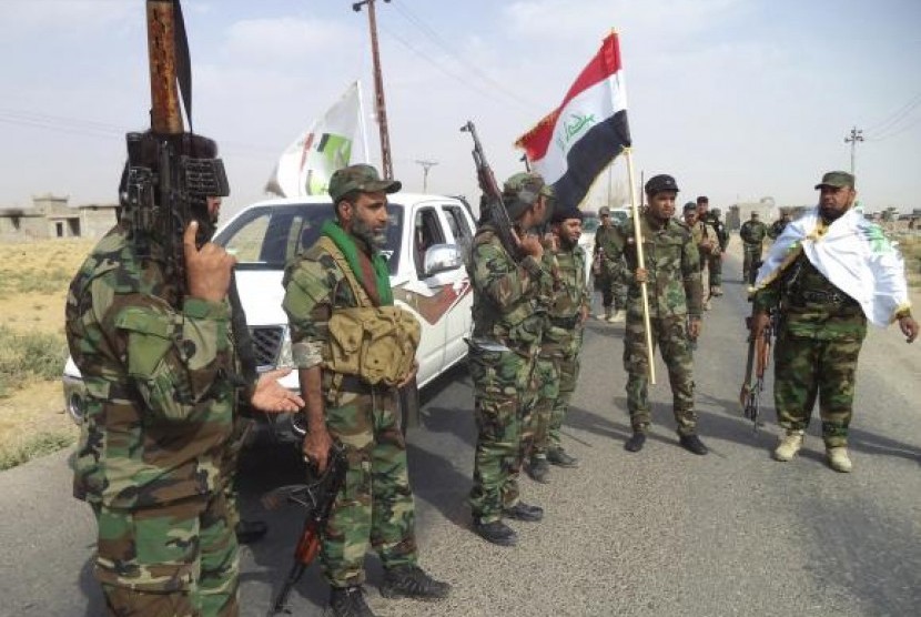 Iraqi Shi'ite militia fighters gather outside Bo Hassan village near Tikrit, northern Iraq October 2, 2014. 