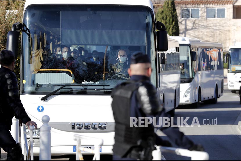 Iring-iringan bis membawa warga negara Perancis yang dievakuasi dari Kota Wuhan dari bandara  Istres-Le Tube dibawa menuju  Carry-le-Rouet.  Selanjutnya mereka akan diisolasi selama 14 hari di selatan Perancis, Jumat (31/1).(Arnold Jerocki/EPA EFE)