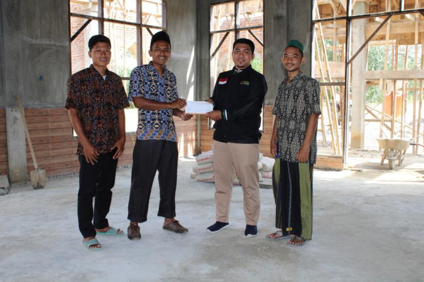 Irvan Mendrofa,manager Program dan Pemberdayaan BMH Sumut (kedua dari kanan)  menyerahkan bantuan untuk pembangunan Masjid Al-Fatah, Kabupaten Langkat.