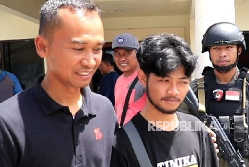 Irwan Maulana (kaos hitam) tersenyum saat dijemput Tim Polda Jabar. Warga Kabupaten Garut ini menjadi korban selamat dalam insiden penembakan KKB di Nduga, Papua. 