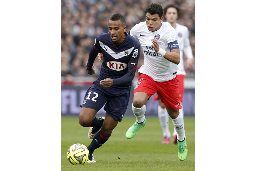 Isaac Kiese Thelin of Bordeaux (L) fights for the ball with Thiago Silva (R) of Paris St Germain during their French Ligue 1 soccer match at Chaban Delmas stadium in Bordeaux, southwestern France, March 15, 2015