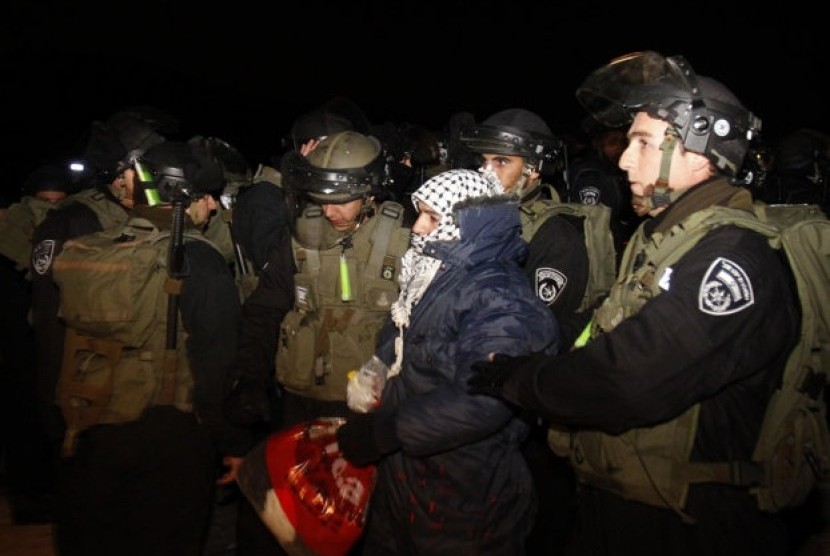 Israeli border police evict a Palestinian activist from an area known as E-1 near Jerusalem, Sunday, Jan 13, 2013. The Palestinian activists were borrowing a phrase and a tactic, usually associated with Jewish settlers, who believe establishing communities