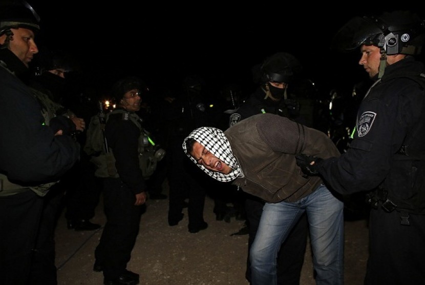Israeli border police remove a Palestinian from an outpost of tents in an area known as E1, near Jerusalem on early Sunday. Palestinians, together with Israeli and foreign activists, erected tents in the area to protest Israeli plans to build a large Jewish settlement. 