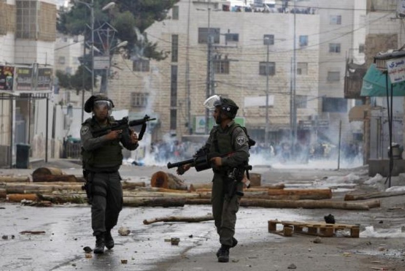 Israeli border policemen take up position during clashes with Palestinian protesters following an anti-Israel demonstration in solidarity with al-Aqsa mosque, in the West Bank city of Hebron November 21, 2014.