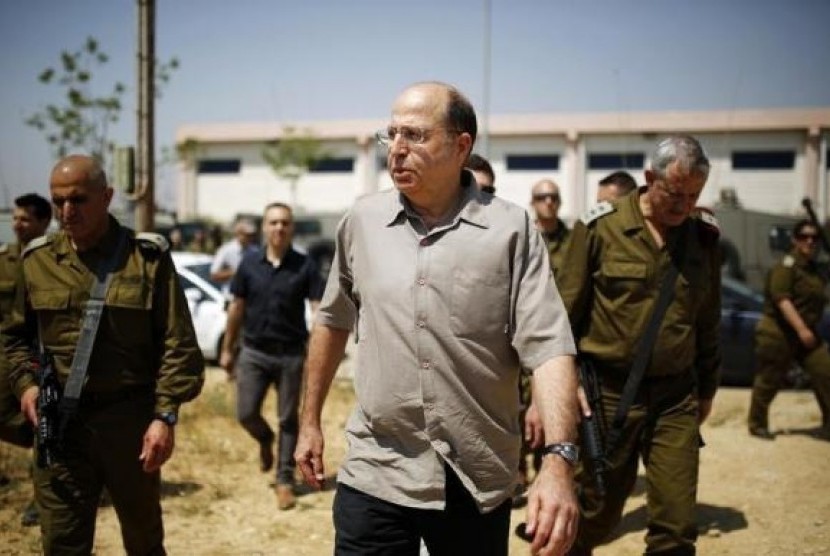 Israeli Defense Minister Moshe Yaalon (center) walks next to Israel's armed forces chief Major-General Benny Gantz (right) during a visit to a military base near Kibbutz Kissufim outside the central Gaza Strip May 7, 2013.