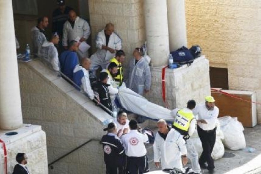 Israeli emergency personnel carry the body of a victim from the scene of an attack at a Jerusalem synagogue November 18, 2014. 