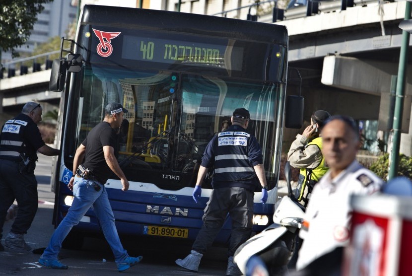 Israeli police crime scene investigators work at the scene of a stabbing attack in Tel Aviv January 21, 2015. A Palestinian man stabbed up to 10 people on a commuter bus in central Tel Aviv on Wednesday before he was shot in the leg by a prison security of