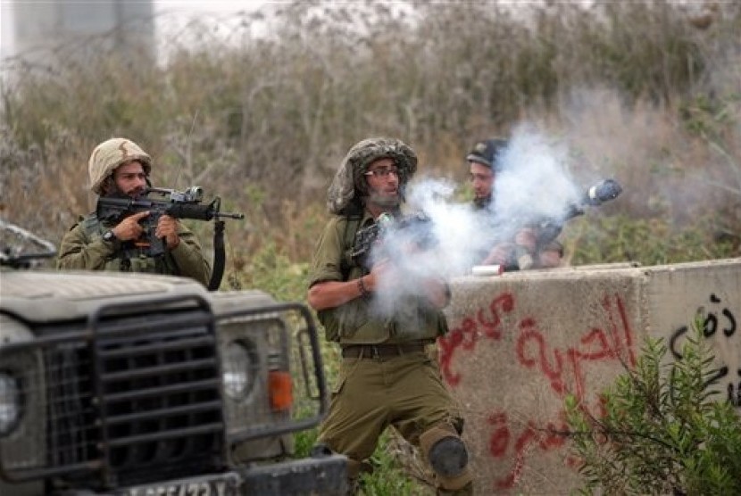 Israeli soldiers fire tear gas towards protesters during a demonstration by Palestinians protesting against the Israeli-built West Bank separation barrier and calling for the right of return for Palestinian refugees, in Tulkarem, May 31, 2014. 