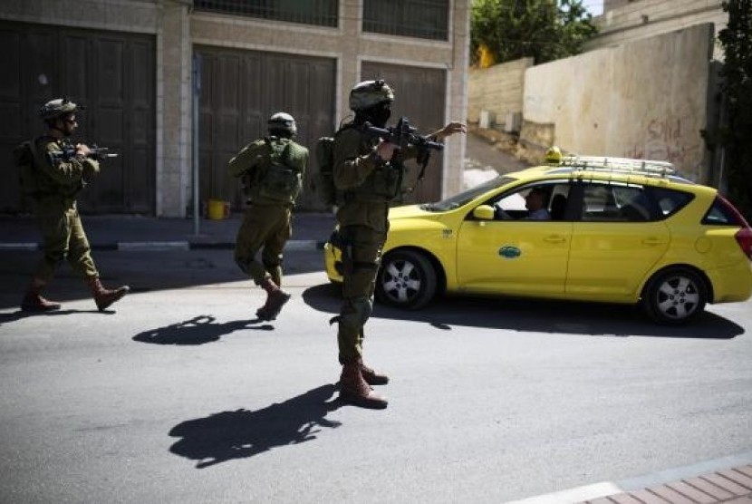 Israeli soldiers take part in an operation to locate three Israeli teens in the West Bank City of Hebron June 17, 2014.