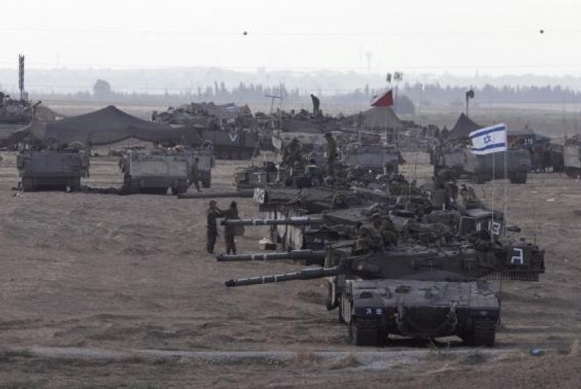 Israeli tanks and armored personnel carriers (APCs) are seen at a staging area outside the central Gaza Strip July 15, 2014.