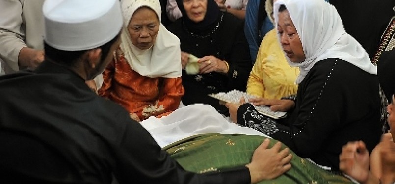 Isteri almarhum KH Zainuddin MZ, Kholilah (kanan), berdoa di dekat jenazah KH Zainuddin MZ di rumah duka, kawasan Gandaria, Jakarta Selatan, Selasa (5/7). 