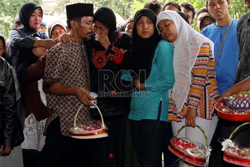   Istri almarhum Bripka Sukardi, Tirta Sari (kedua kiri) bersama putri pertamanya Dita Kardina (kedua kanan) dan putri keduanya Devi Novita (kanan) berdoa di Pemakaman TPU Kemiri, Jakarta Timur, Rabu (11/9). (Republika/Adhi Wicaksono)