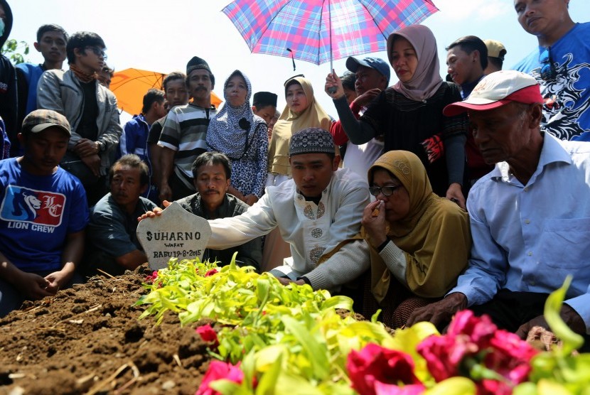 Istri dan Putra almarhum Pelatih Arema Cronus Suharno berdoa di pusara di Desa Bendosewu, Blitar, Jawa Timur, Kamis (20/8).