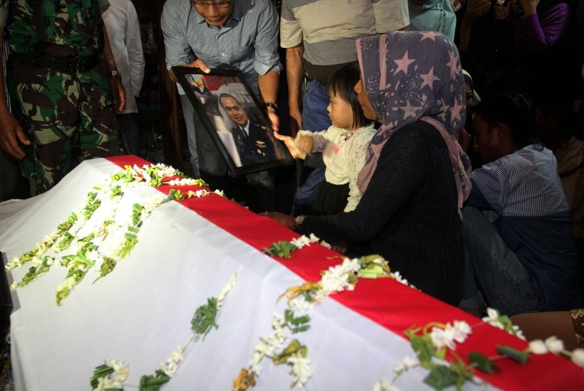 Istri dan putri korban pesawat Hercules C-130 jatuh memperhatikan foto almarhum Kapten Navigasi Riri Setiawan sebelum dimakamkan di Taman Makam Pahlawan, Kabupaten Tanah Datar, Sumatera Barat, Rabu (1/7) malam. 