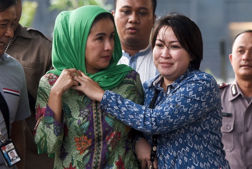 Istri Gubernur Bengkulu Lily Martiani Maddari (kiri) dikawal petugas KPK saat diamankan ke gedung KPK, Jakarta, Selasa (20/6).