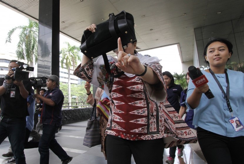 Istri Irman Gusman, Liestyana Rizal Gusman, menghindari wartawan saat mendatangi gedung KPK, Jakarta, Senin (26/9). 