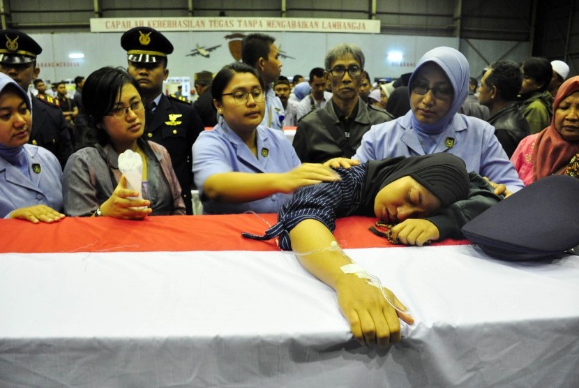 Istri Lettu Penerbang Hanggo Fitriadhi, Rika, memeluk peti jenazah suaminya yang menjadi korban jatuhnya pesawat Hercules A-1334 saat disemayamkan di Hanggar Skadron 32 Lanud Abdulrahman Saleh, Malang, Jawa Timur, Ahad (18/12).