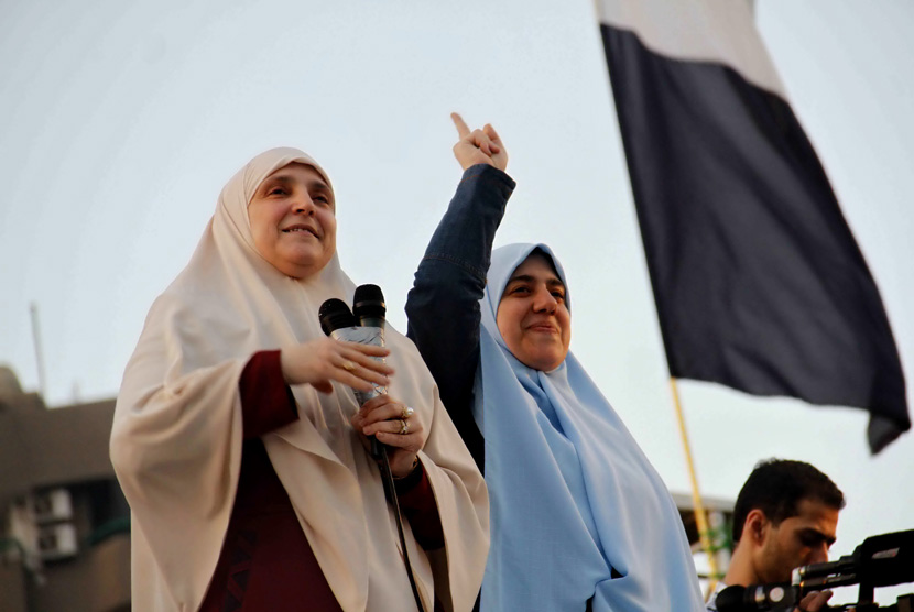 Istri Presiden Muhammad Mursi Naglaa Mahmoud (kiri) berpidato kepada para pendukung Mursi di Masjid Rabaah al-Adawiya, Kairo, Kamis (8/8).   (AP/Ravy Shaker/El Shorouk Newspaper)