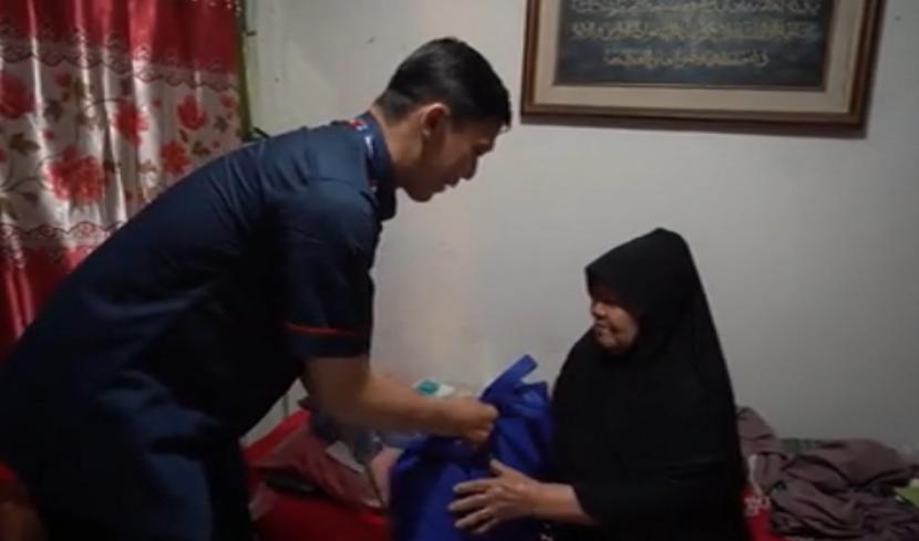Istri seorang pensiunan, Wainem (80) menerima uang pensiunan suaminya dari petugas.