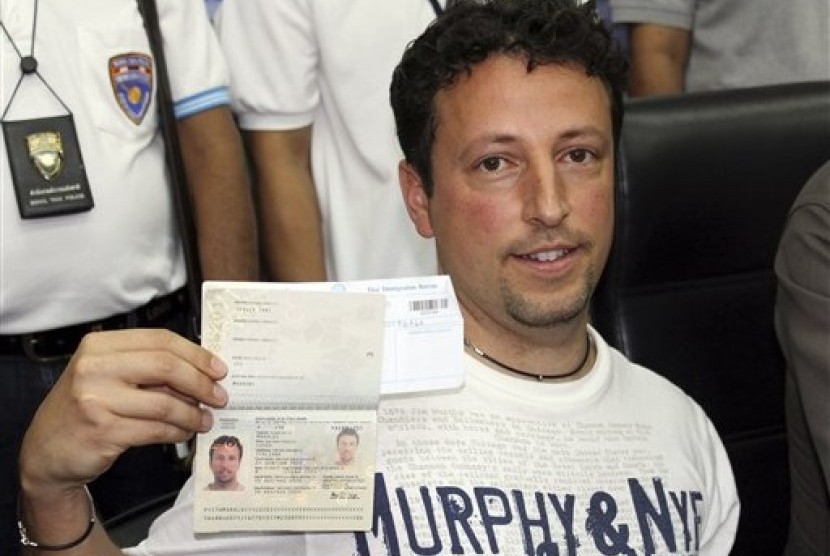 Italian Luigi Maraldi whose stolen passport was used by a passenger boarding a missing Malaysian airliner, shows his passport as he reports himself to Thai police at Phuket police station in Phuket province, southern Thailand Sunday, March 9, 2014.