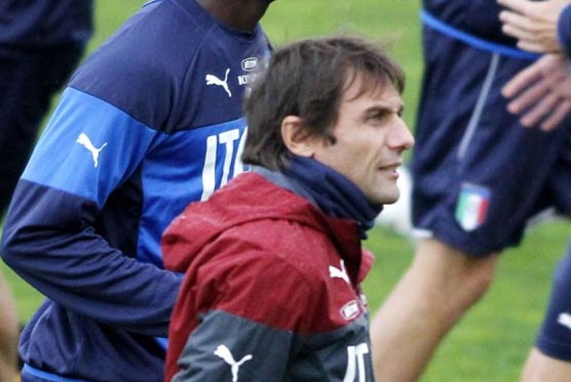 Italian national soccer team's Mario Balotelli runs past coach Antonio Conte, during a training session with the team at the Coverciano Training Center, near Florence, central Italy, Monday, Nov.10, 2014. Italy will play Croatia in Milan on Sunday in a Eur