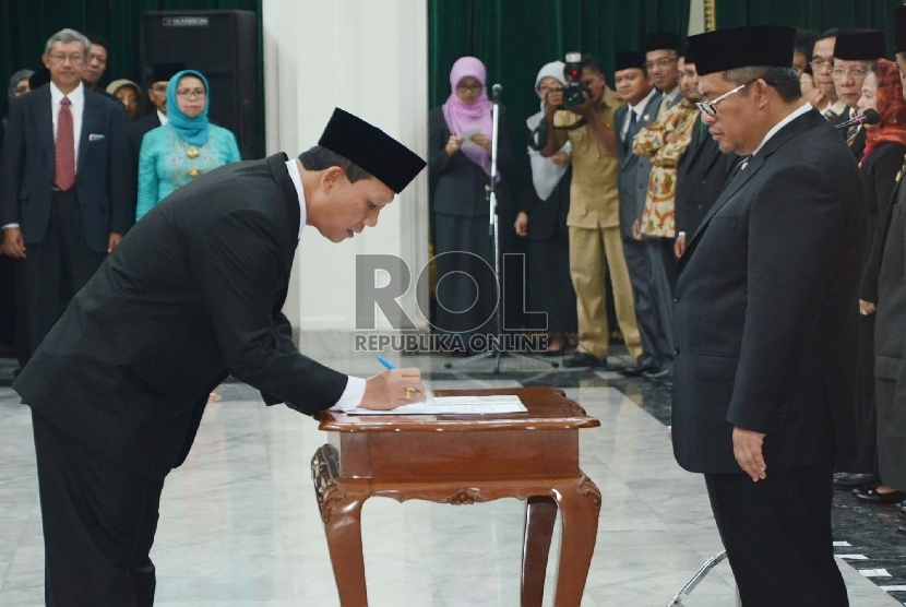 Iwa Karniwa (kiri) mendatangani SK pelantikan dirinya sebagai Sekretaris Daerah Provinsi Jabar disaksikan oleh Gubernur Jabar Ahmad Heryawan, di Gedung Sate, Kota Bandung, Senin (12/10). 