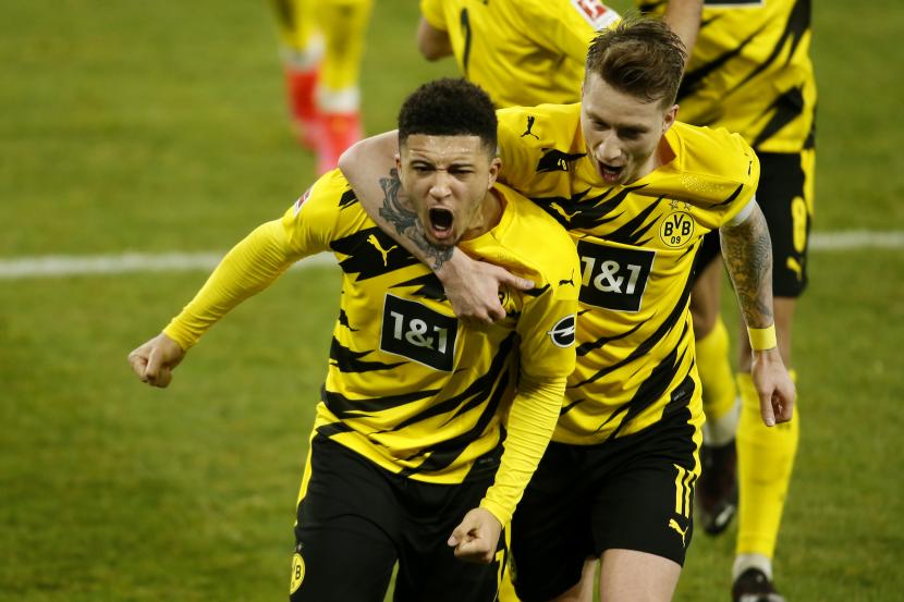 Jadon Sancho dari Dortmund merayakan gol bersama Marco Reus. 