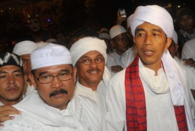 Jakarta governor Jokowi (right with red scarf) join the Jakarta Night Religious Festival parade on Monday, Oktober 14, 2013