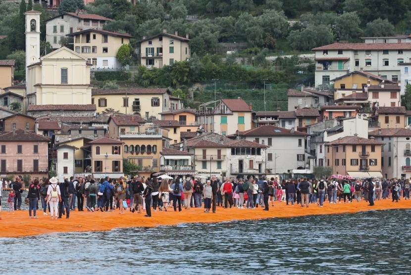 Jalan mengambang buatan seniman Christo dipadati pengunjung yang ingin merasakan sensasi melangkah di atas air di Danau Iseo, Italia.