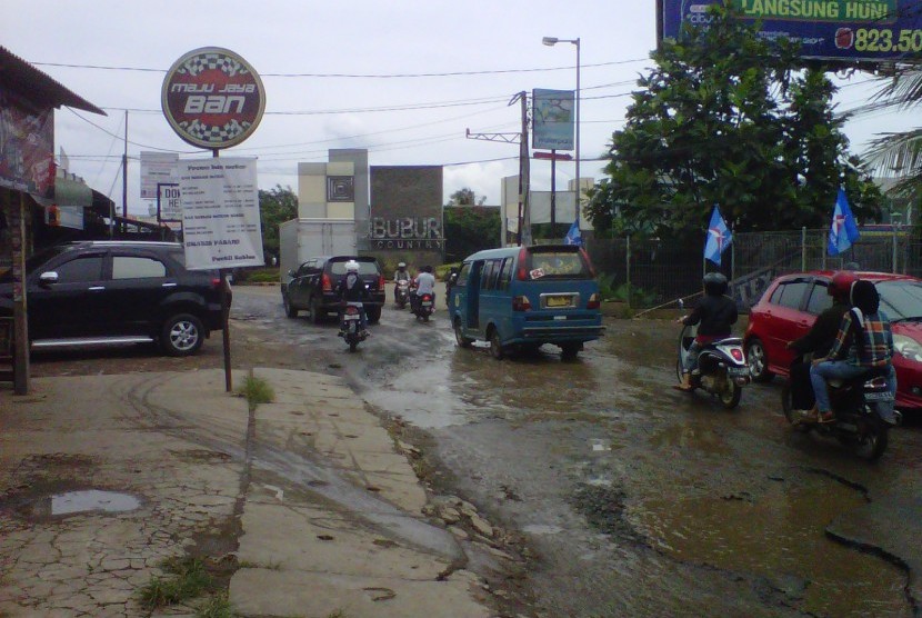 Jalan Raya Letda Natsir Cikeas, Gunung Putri, Bogor, yang rusak berat, Rabu (20/2). Musim hujan membuat kerusakan jalan yang terletak di depan Puri Cikeas, kediaman Presiden SBY, tersebut bertambah parah.