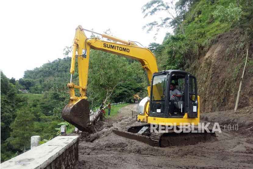 Warga menyeberangi banjir bandang yang memutus jalur lintas selatan Desa Hadiwarno, Pacitan, Jawa Timur, Selasa (28/11). 