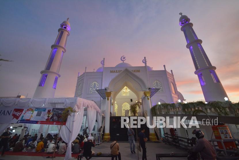 Jamaah berbuka puasa bersama di halaman Masjid Al-Hakim, Padang, Sumatera Barat, Kamis (15/4/2021). Masjid Al-Hakim yang merupakan ikon wisata halal di kota itu menyediakan sebanyak 150 paket buka puasa setiap hari selama bulan Ramadhan. 