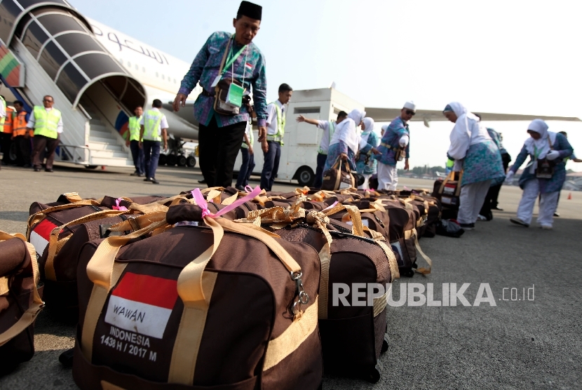 Jamaah Calon Haji asal Garut bergegas menaiki pesawat pada keberangkatannya di Bandara Soekarno-Hatta, Tanggerang, Banten, Kamis (8/3).