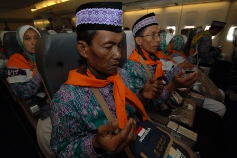 Jamaah calon haji berdoa di pesawat sebelum terbang ke Tanah Suci