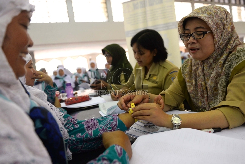  Jamaah calon haji Kloter 7 dari Tangerang menjalani pemeriksaan oleh petugas kesehatan saat tiba di Asrama Haji Pondok Gede, Jakarta, Selasa (25/8).    (Republika/Wihdan)