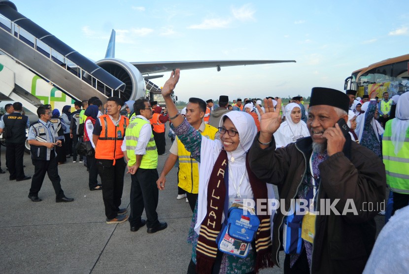 Jamaah calon haji melambaikan tangan kepada keluarga mereka, menjelang keberangkatan kloter pertama embarkasi Padang, di Bandara Internasional Minangkabau (BIM), Padangpariaman, Sumatera Barat, Selasa (17/7). 