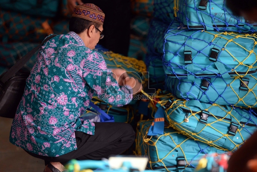 Jamaah calon haji memasang pita koper di Asrama Haji Pondok Gede, Jakarta, Kamis (10/9).