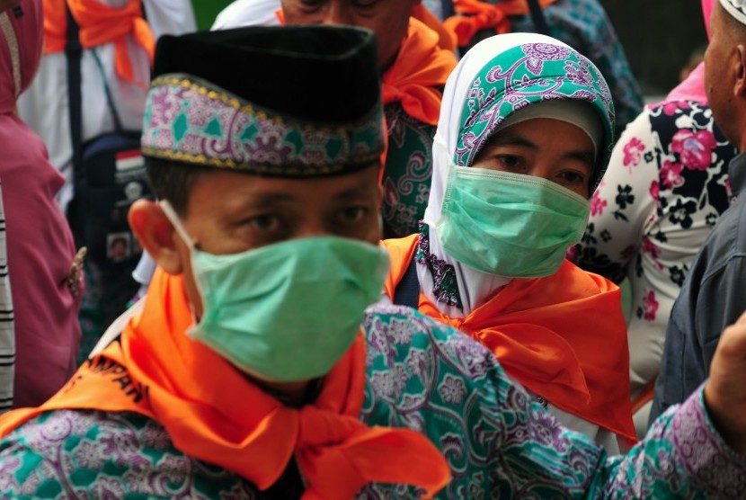 Jamaah calon haji menggunakan masker saat menunggu kepastian keberangkatan ke Embarkasi Batam, di Kota Pekanbaru, Riau, Rabu (2/9).  