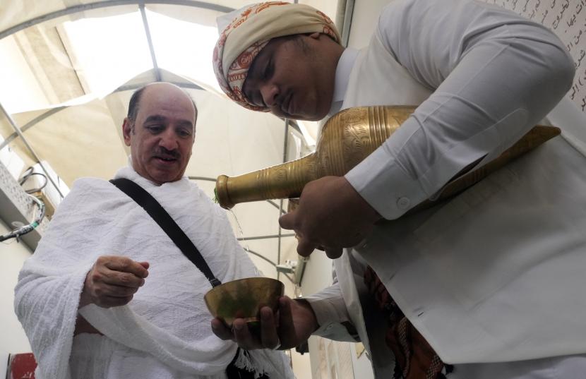 Jamaah haji Abdallah Al Otaibi, dari Arab Saudi, menerima secangkir air Zamzam suci selamat datang pada saat kedatangannya di kamp tenda Mina, selama haji, di Makkah, Arab Saudi, Kamis, 7 Juli 2022. Parlemen Arab Memuji Upaya Saudi Memfasilitasi Layanan Jamaah Haji