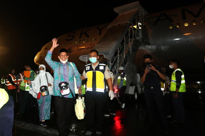 Jamaah haji Aceh melambaikan tangan setibanya di Bandara Sultan Iskandar Muda, Blang Bintang, Aceh Besar, Aceh, Selasa (26/7/2022). Petugas Kloter Aceh Ikuti Pelatihan Sistem Pelaporan Elektronik Haji