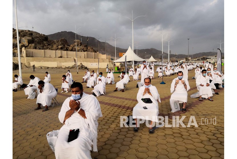 Ini Perbedaan Ibadah Haji dan Umroh. Jamaah haji berdoa di Jabal Rahmah di Arafah dengan memakai masker dan menjaga jarak sosial guna menghindari penyebaran virus corona di Arafah, Arab Saudi, Kamis (30/7/2020).