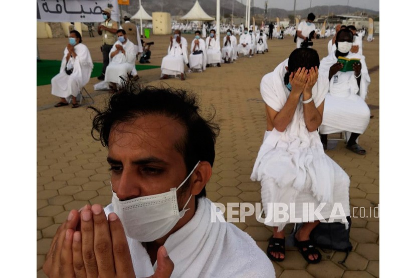 Jamaah haji berdoa di Jabal Rahmah di Arafah dengan memakai masker dan menjaga jarak sosial guna menghindari penyebaran virus corona di dekat kota suci Mekah, Arab Saudi, Kamis (30/7/2020).