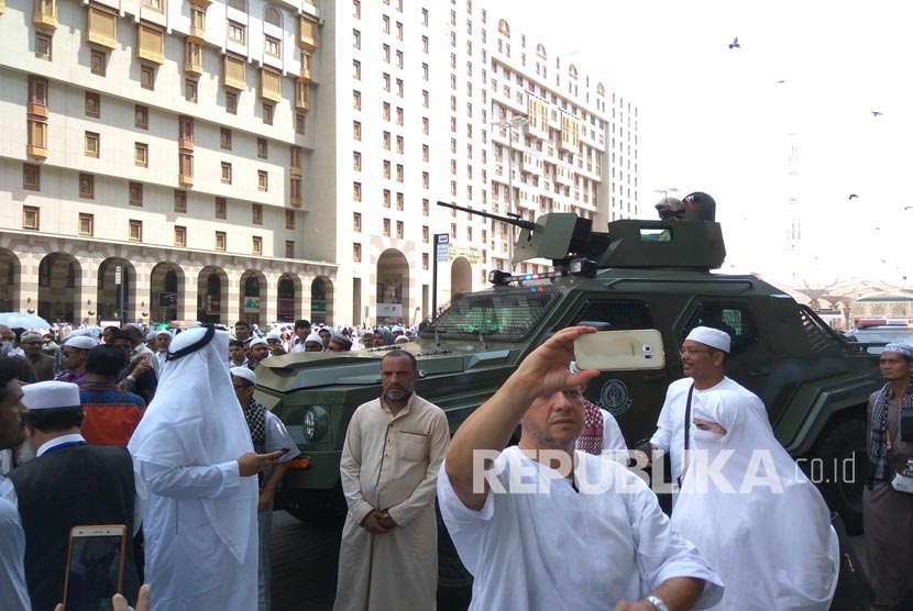   Jamaah haji berswafoto depan kendaraan taktis aparat keamanan Arab Saudi dekat Masjid Nabawi, Jumat (26/8).  (Republika/Amin Madani)