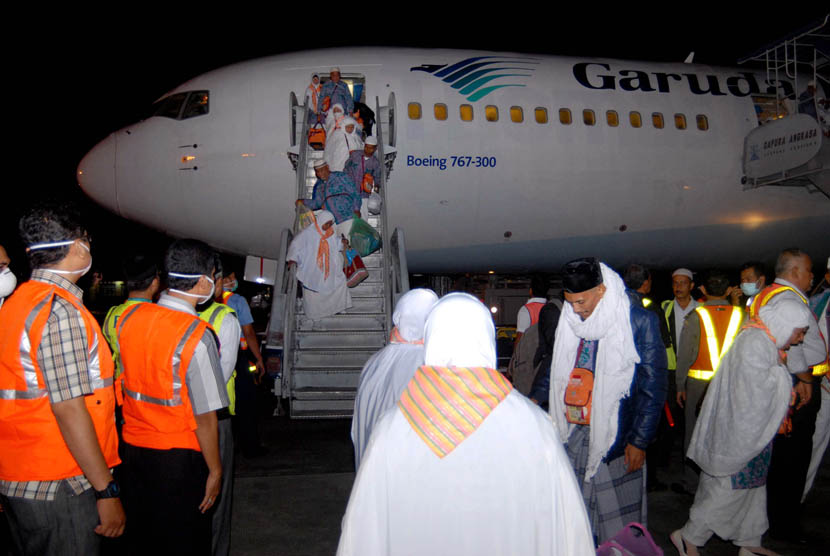  Jamaah haji kloter pertama asal Aceh turun dari pesawat saat tiba di Bandara Internasional Sultan Iskandar Muda, Aceh Besar, Rabu (31/1) malam.   (Ampelsa/Antara)