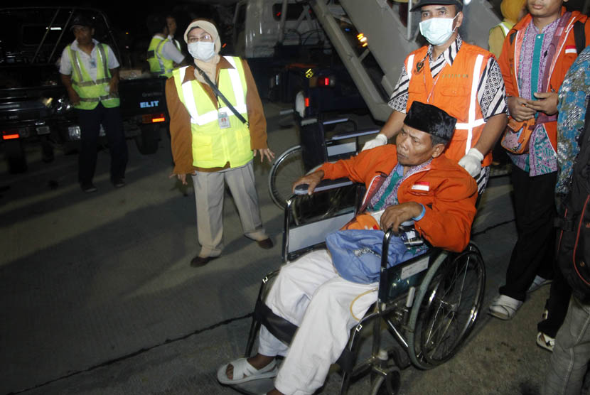 Jamaah Haji Kloter pertama Debarkasi Surakarta asal Kabupaten Sukoharjo yang sakit menggunakan bantuan kursi roda menuju mobil ambulans setibanya di Bandara Adi Sumarmo, Boyolali, Jawa Tengah, Kamis (1/11) dinihari.   (Herka Yanis Pangaribowo/Antara)