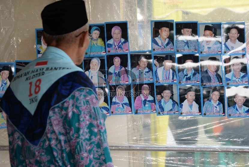  Jamaah Haji melihat foto hasil jepretan tukang foto di kawasan Asrama Haji Pondok Gede, Jakarta, Rabu (2/9).   (Republika/ Yasin Habibi)