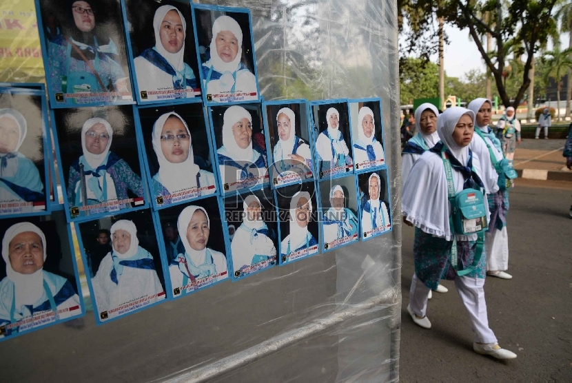 Jamaah Haji melihat foto hasil jepretan tukang foto di kawasan Asrama Haji Pondok Gede, Jakarta, Rabu (2/9).   (Republika/ Yasin Habibi)