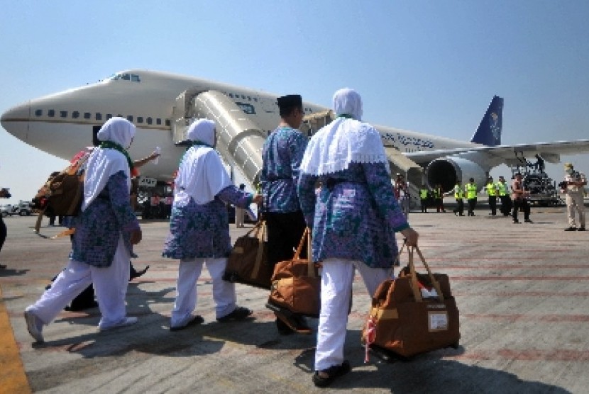 Jamaah haji menaiki pesawat yang akan membawa mereka ke Tanah Suci.